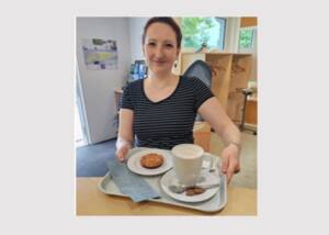 Frau mit Kaffee, Kuchen und blauem Kassenzettel