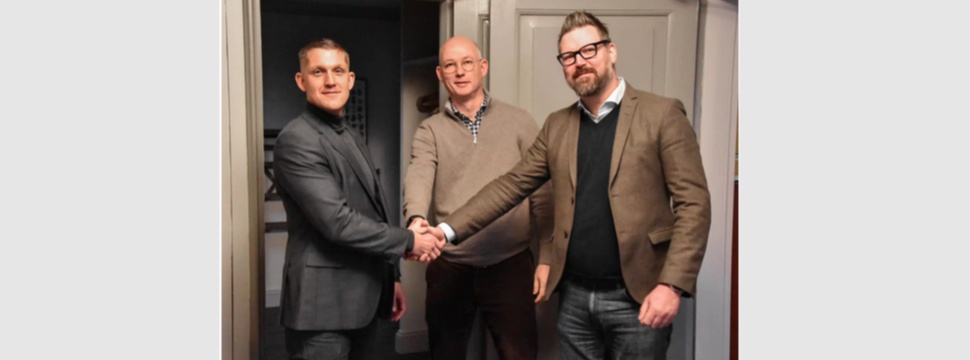 Jens Olson, CEO von Lessebo Paper (links), schüttelt Trond Erik Isaksen, Sales Director bei Livonia Print, und Markus Guldstrand, Production Director bei Bonnier Books, die Hand.
