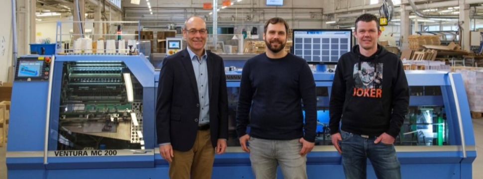 Managing Partner Richard Wenig (center) with Plant Manager Daniel Pelz (right) and Matthias Kandt (Area Sales Manager Muller Martini Germany) in front of the new Ventura MC 200 book sewing machine.