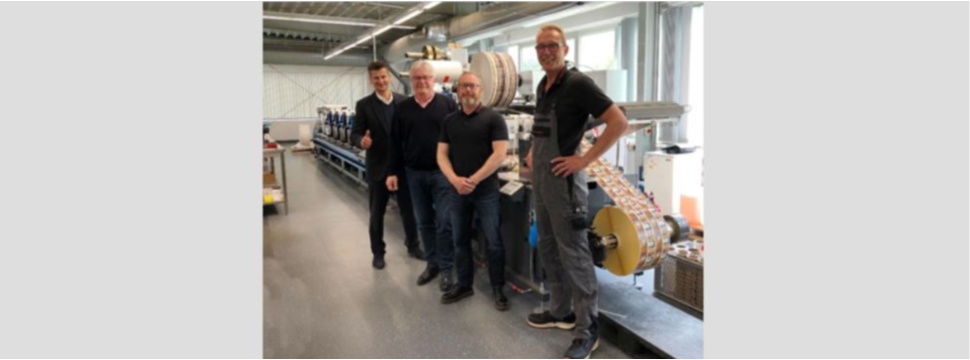 Photo From left to right: Michael Koch from Heidelberg Deutschland, with Eugen Kölling (owner), Andreas Hansen (head of production) and Stefan Bollens (operator) from HP-ETIKETT in front of one of the two Labelmaster, both installed in 2021