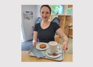Woman with coffee, cake and blue checkout receipt